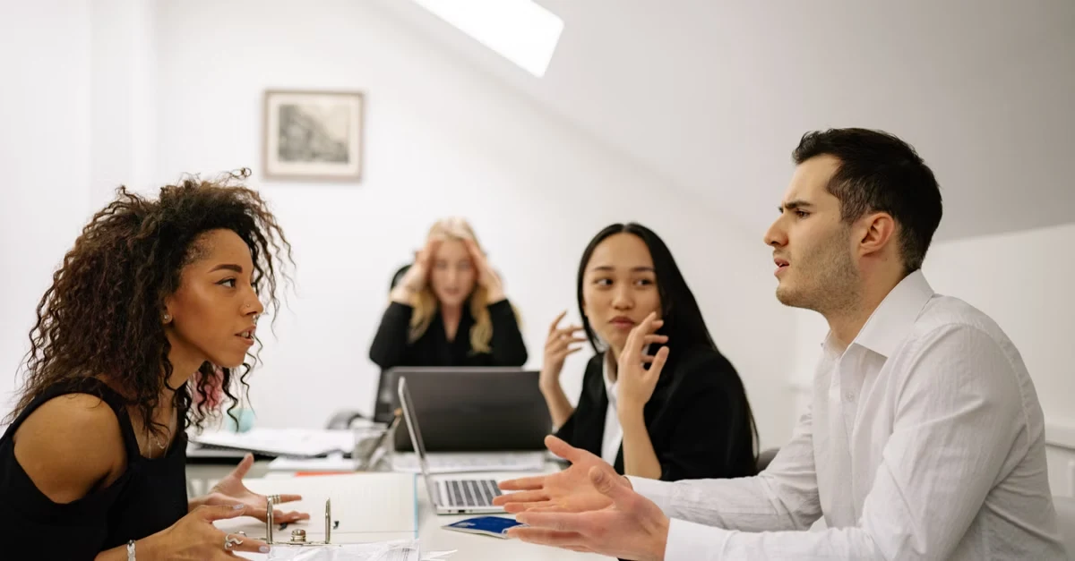 Project management executive assistants collaborating during team meeting in modern office conference room.