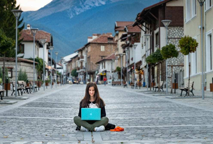 a creative remote assistant sitting on the street