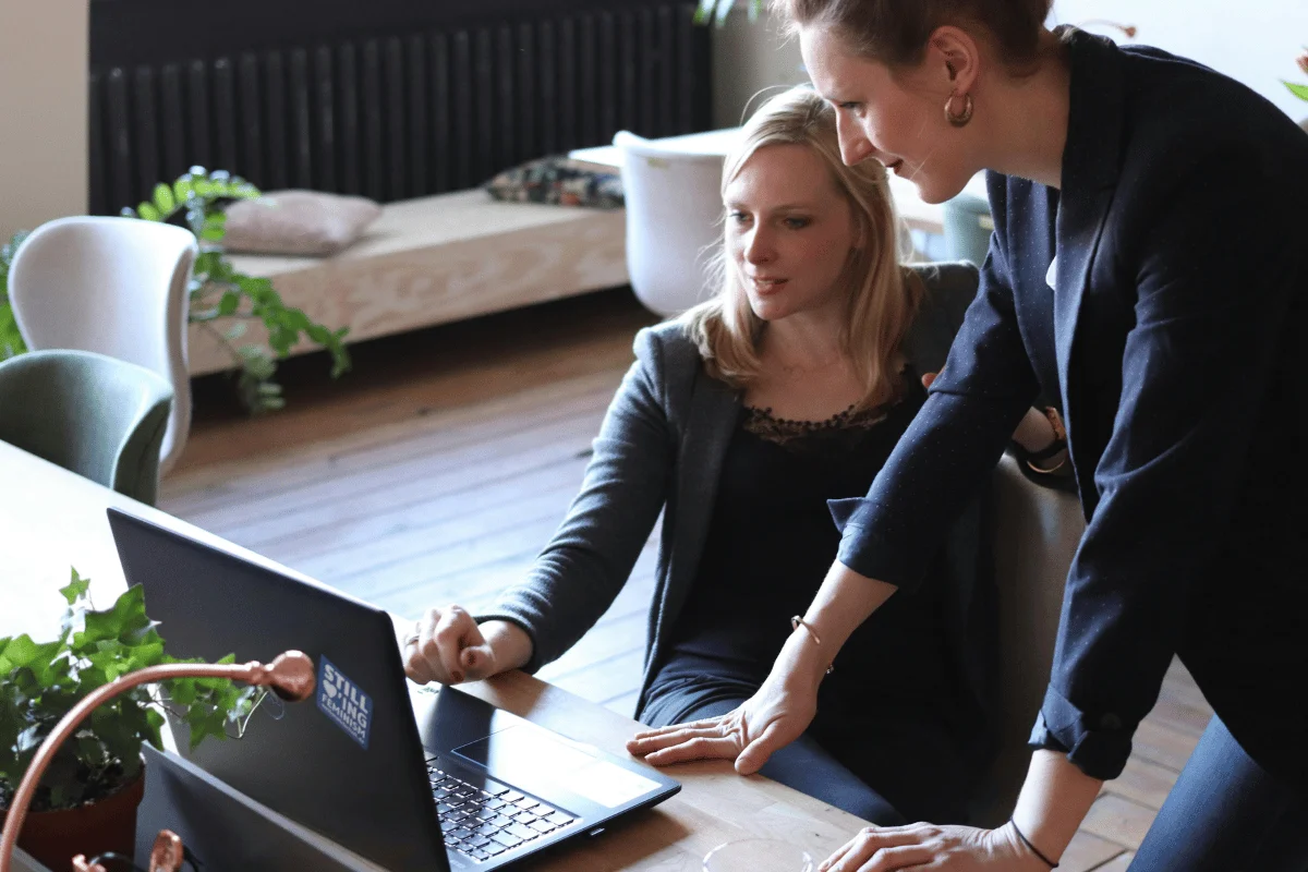 Business professionals engaging in a collaborative discussion while analyzing information on a laptop.