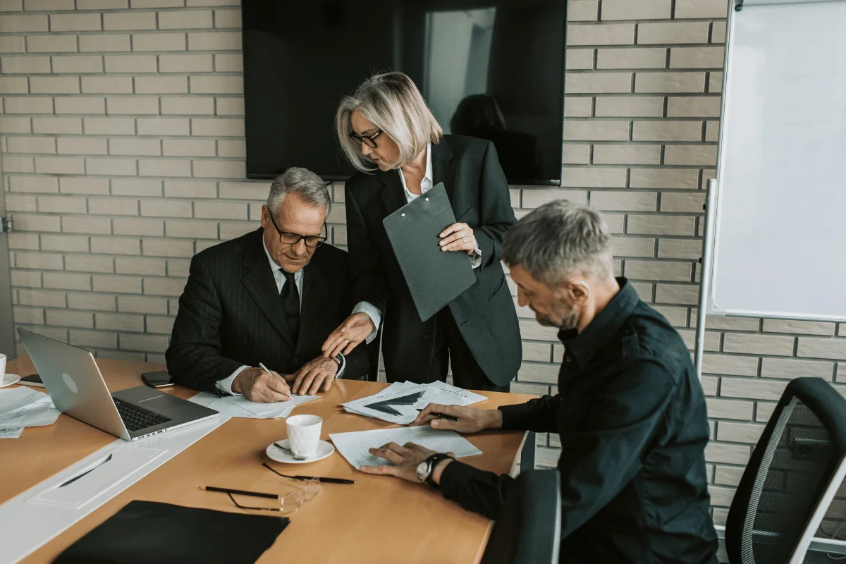 Business meeting with executives reviewing documents in office.