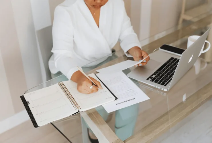 A corporate professional reviewing legal documents and making notes while working remotely.