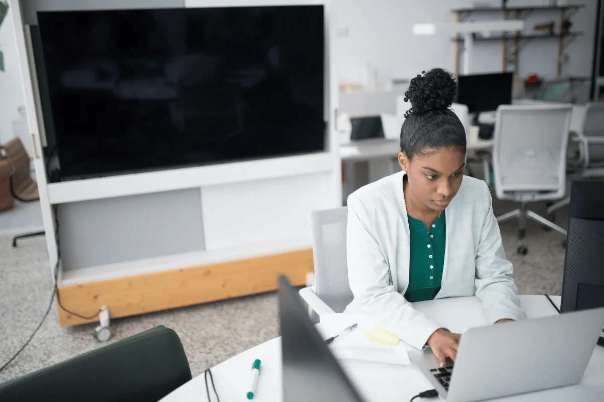 Executive assistant working on laptop in a modern office.
