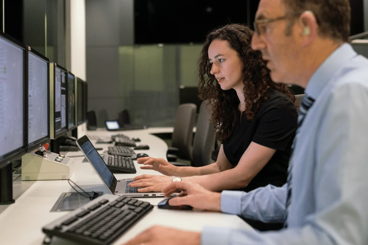 Executive assistant supporting operations while monitoring multiple computer screens.