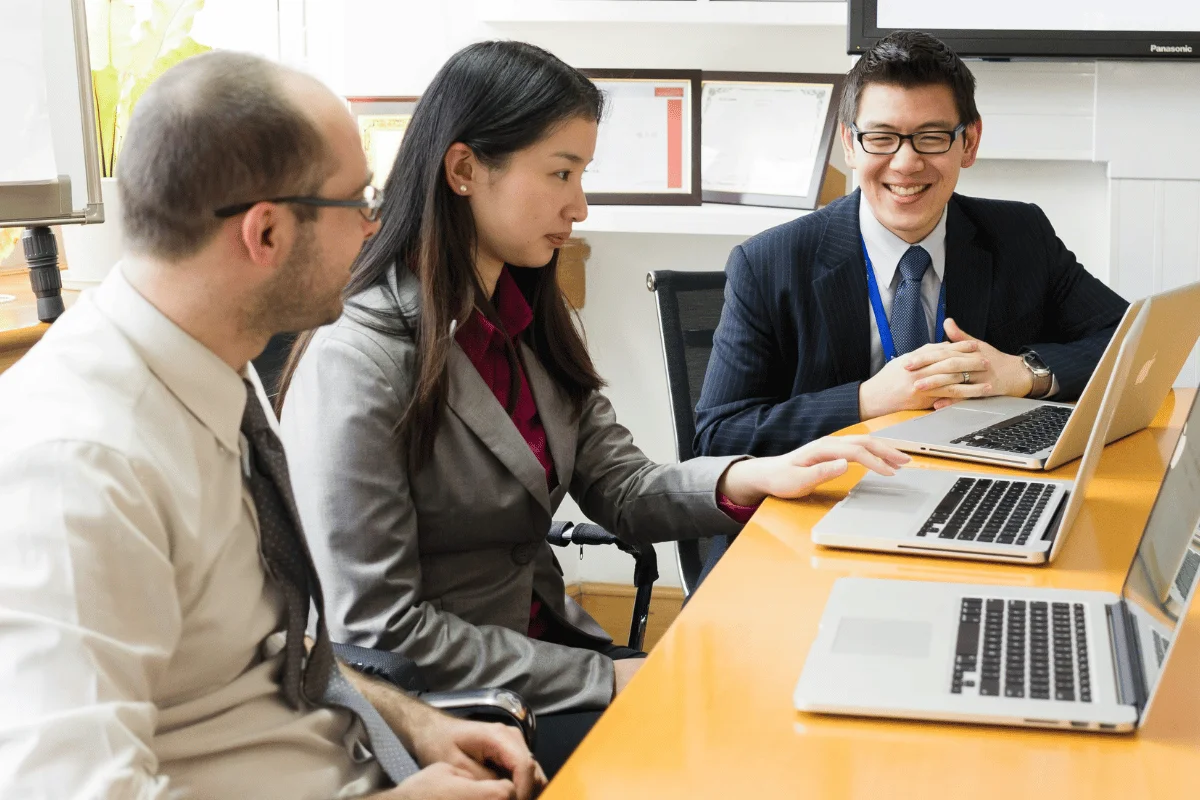 Executive assistants collaborating with managers during business meeting.