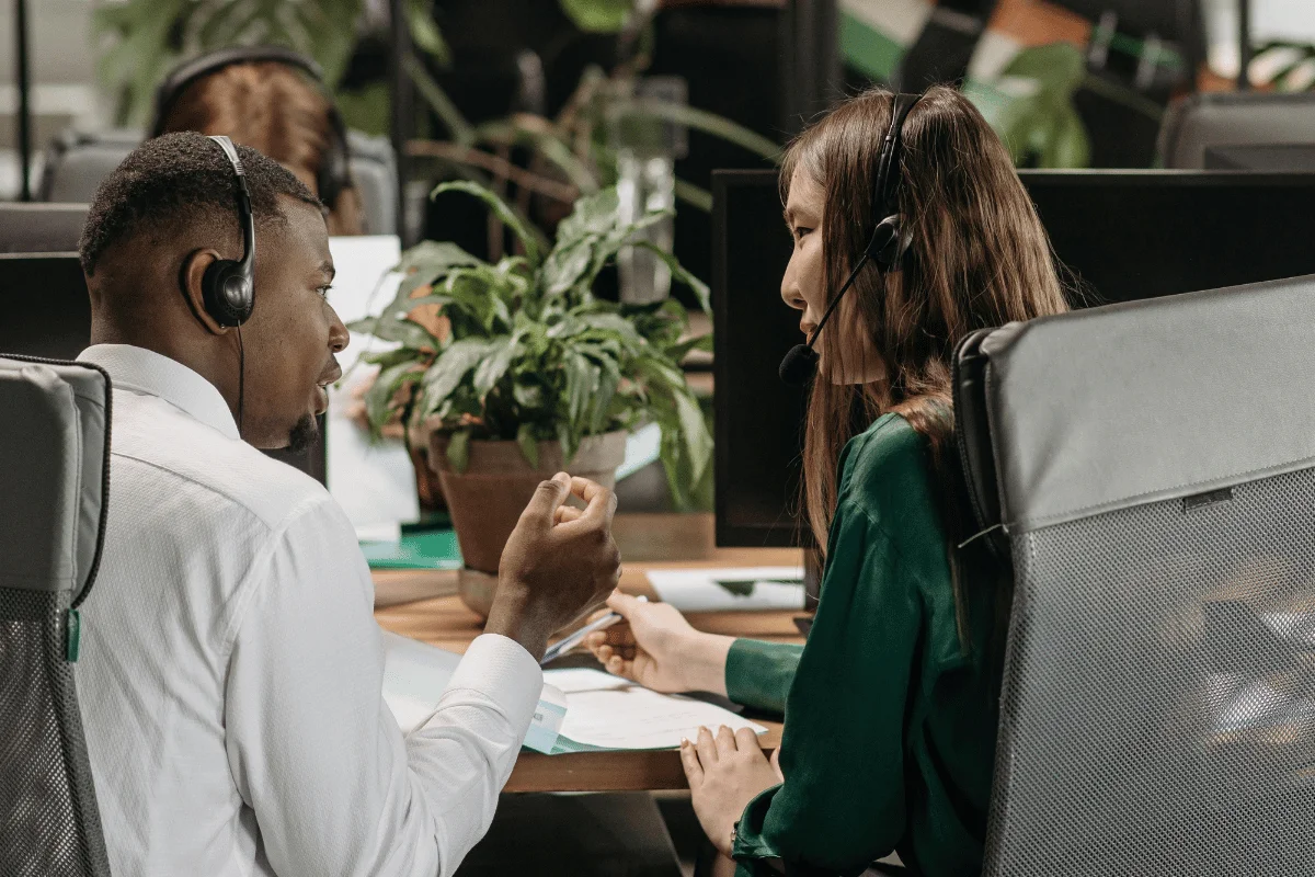 Team members with headsets talking in a modern office.