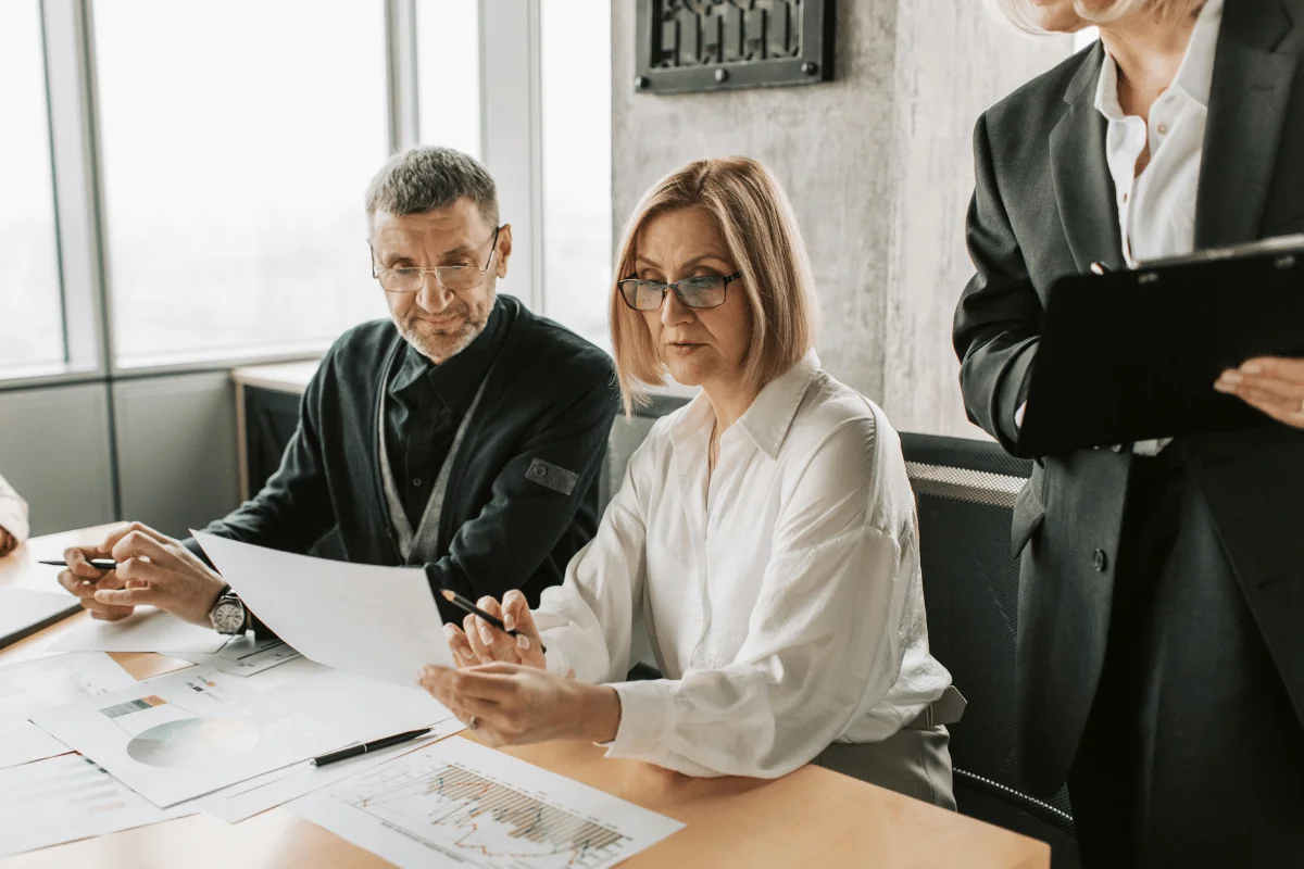 Business professionals analyzing charts and data in a meeting.