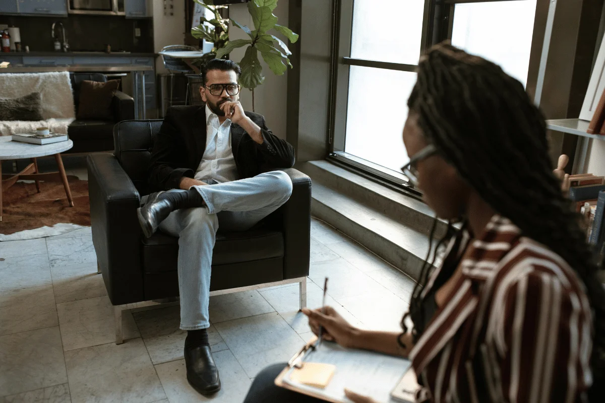 Man sitting on a chair in deep thought during a consultation.