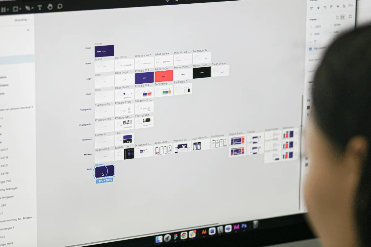 Person viewing a computer screen displaying a design document. The interface includes various colored blocks, text labels, and a menu bar.