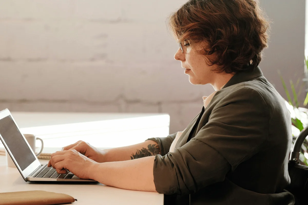 Professional woman working on a laptop at a desk.