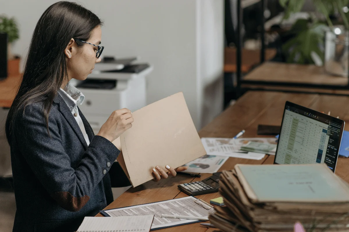 Female professional reviewing documents at office desk.