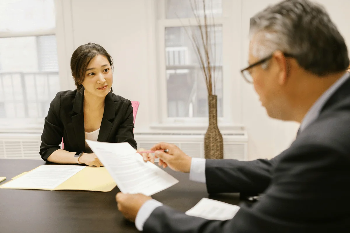 A woman attentively listens to a man during a business meeting. 