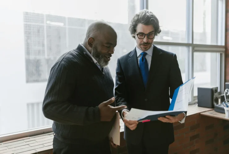 Businessman presenting a report to a colleague in an office setting.