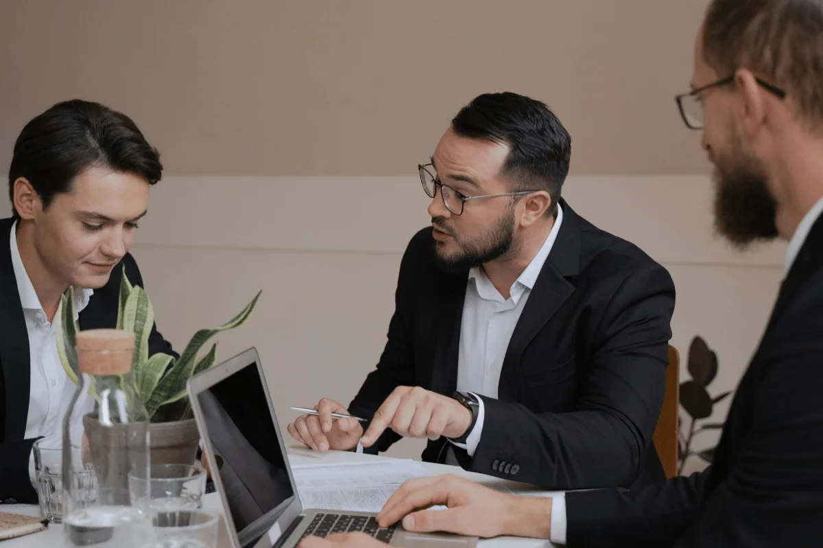 Business team having a focused meeting around a laptop.