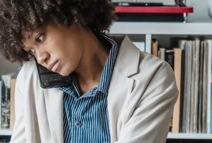 Woman reviewing documents while talking on the phone.