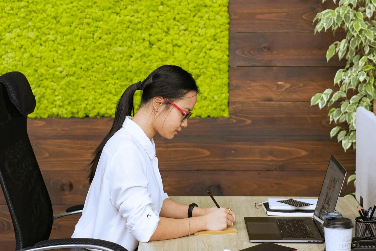 Focused virtual assistant taking notes while working remotely.