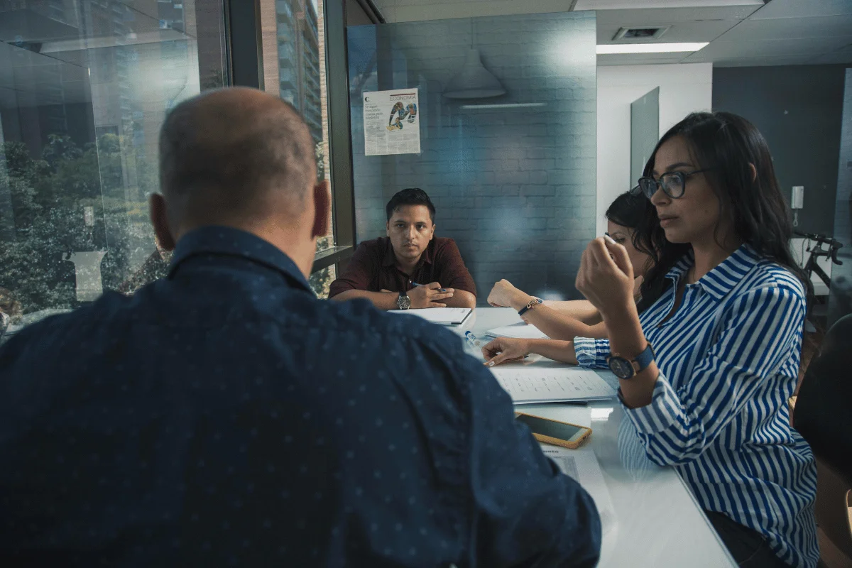 Business team brainstorming around a table in a modern office meeting room.