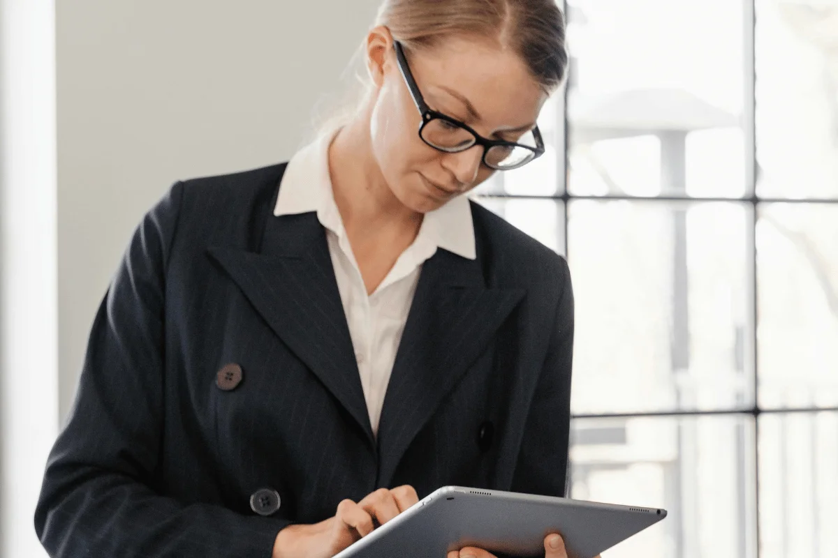 Businesswoman in formal attire working on a tablet in office.