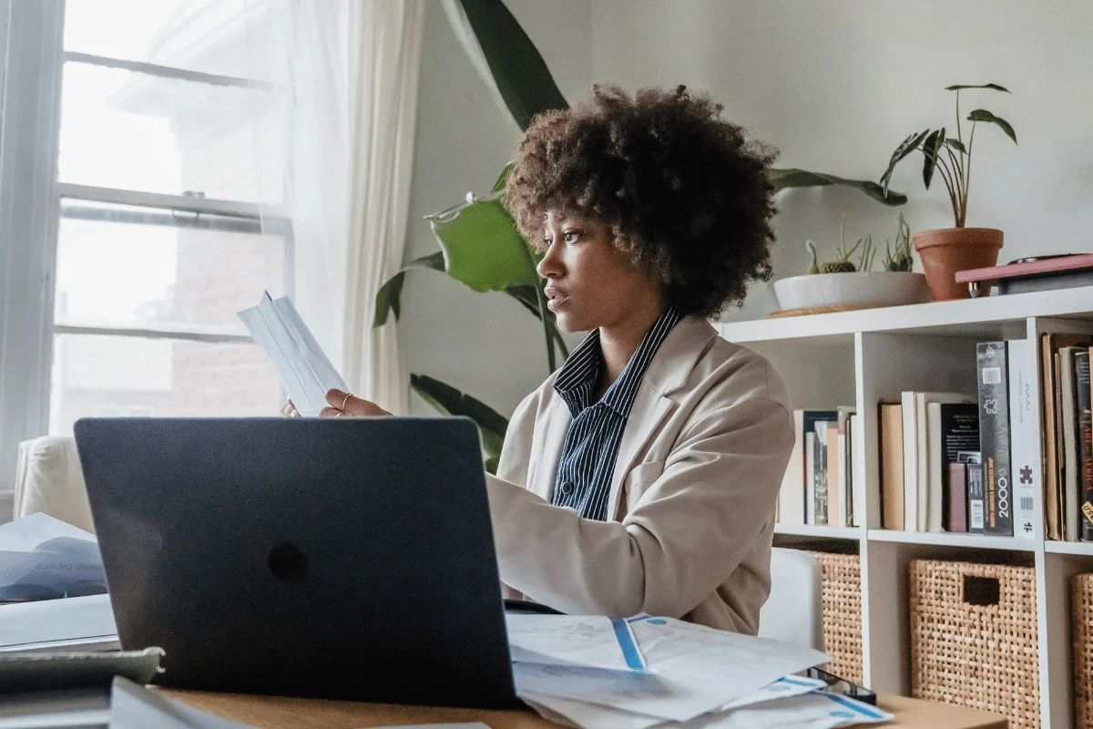 Woman analyzing documents in a bright, modern workspace.