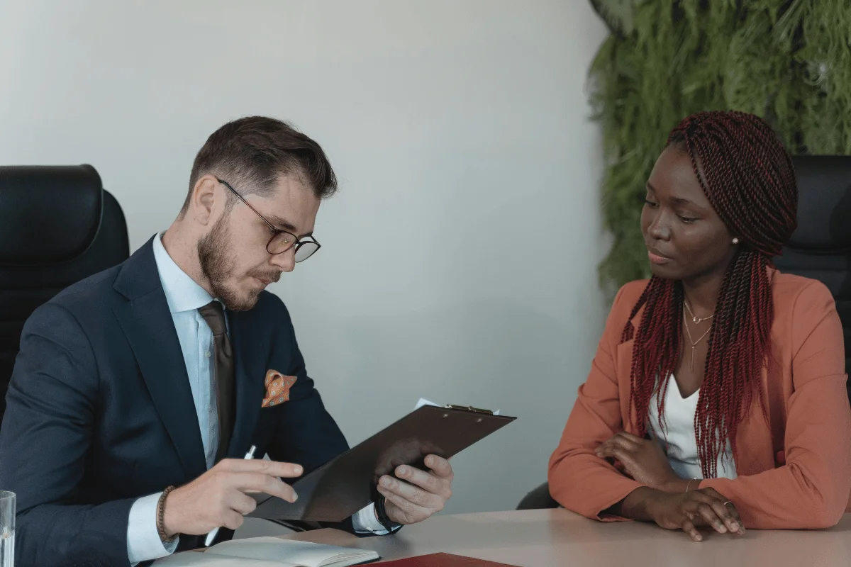 Business meeting between a man in a suit and a woman in a blazer.