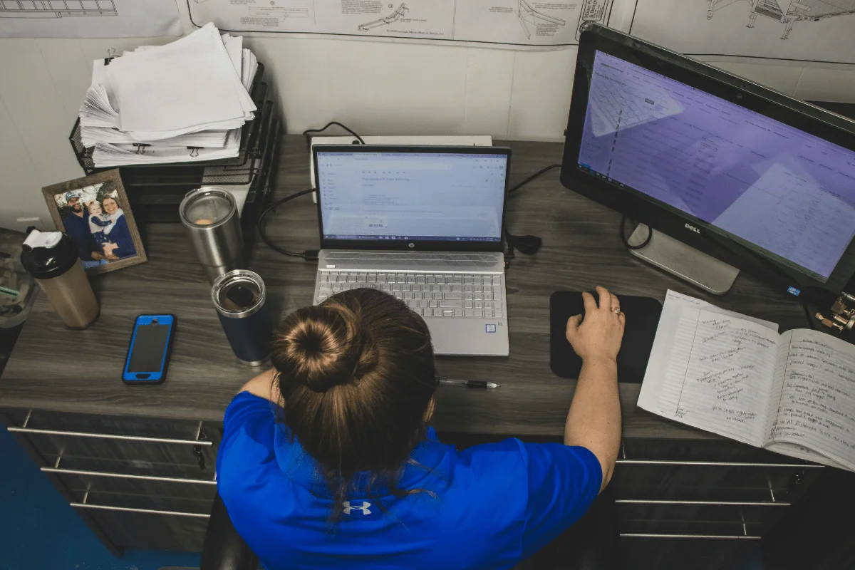 Woman typing and analyzing data at workstation.