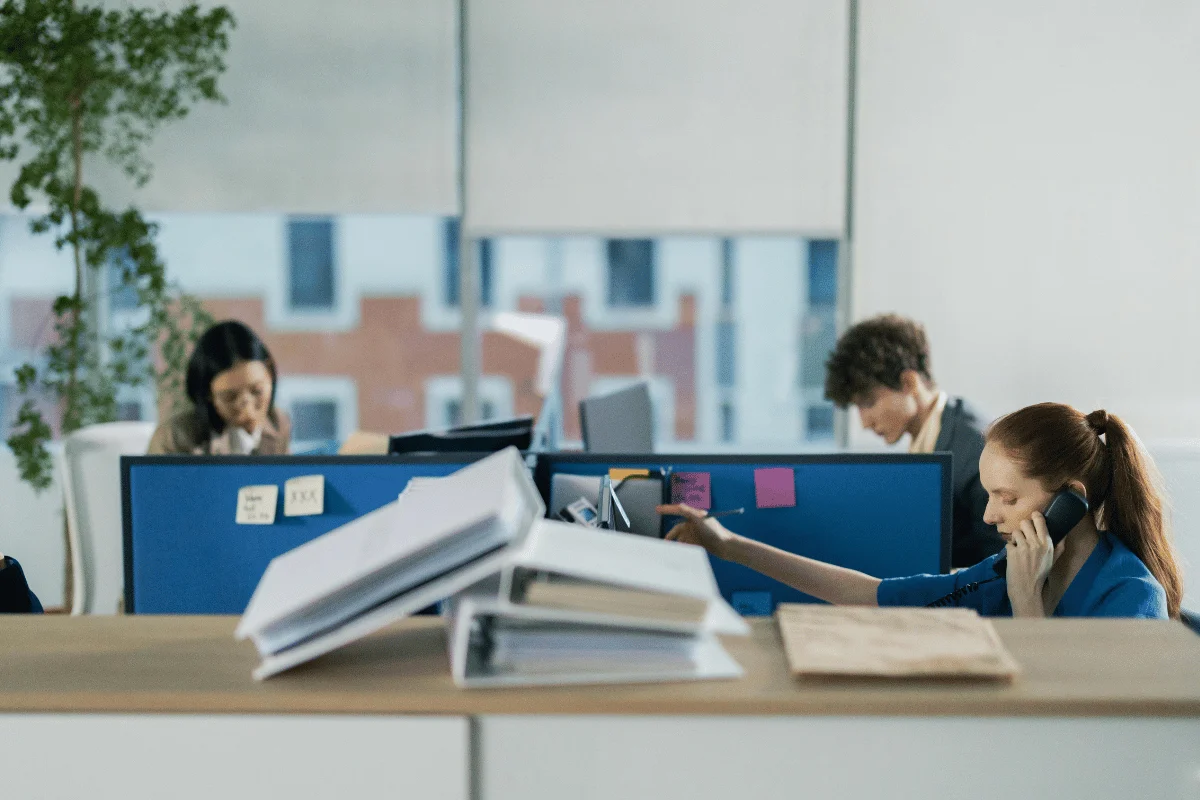 Admin assistant managing office tasks with documents and phone.