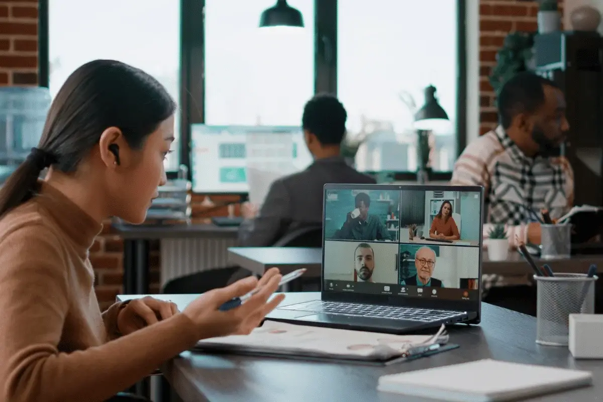Young businessman smiling during a meeting while using a laptop.