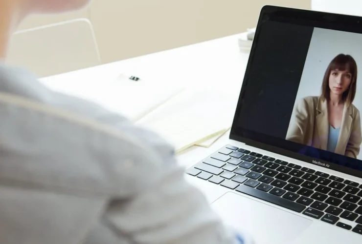 Woman on laptop video call with female virtual assistant candidate during remote job interview.