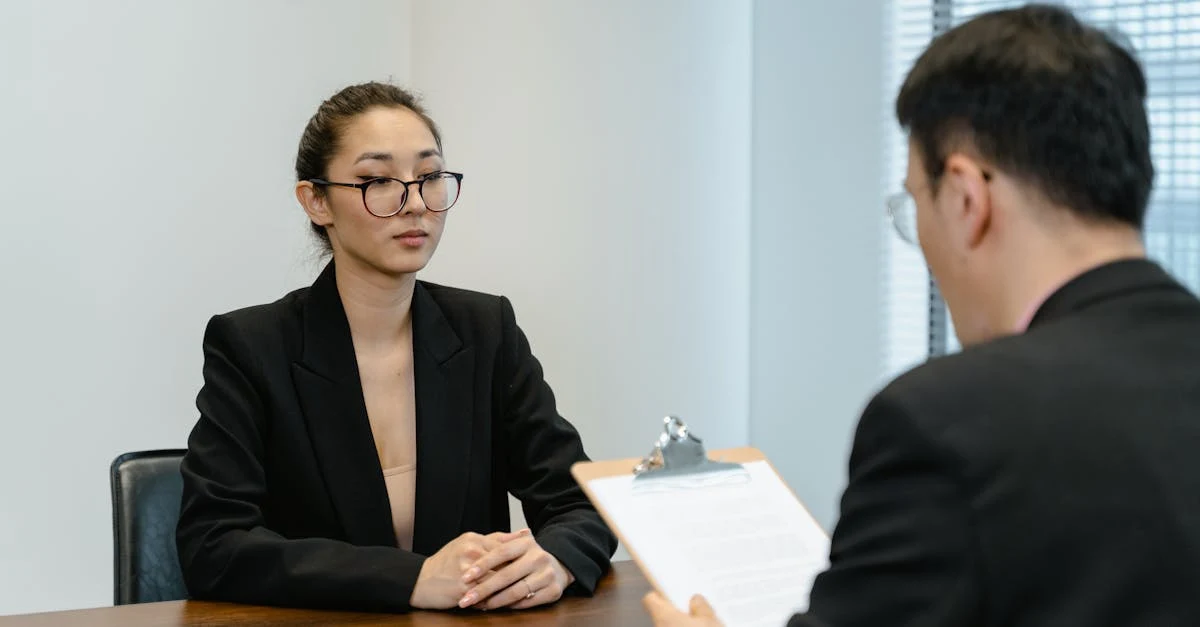 Woman in business attire conducting job interview across desk with outsourced executive assistant candidate evaluation.