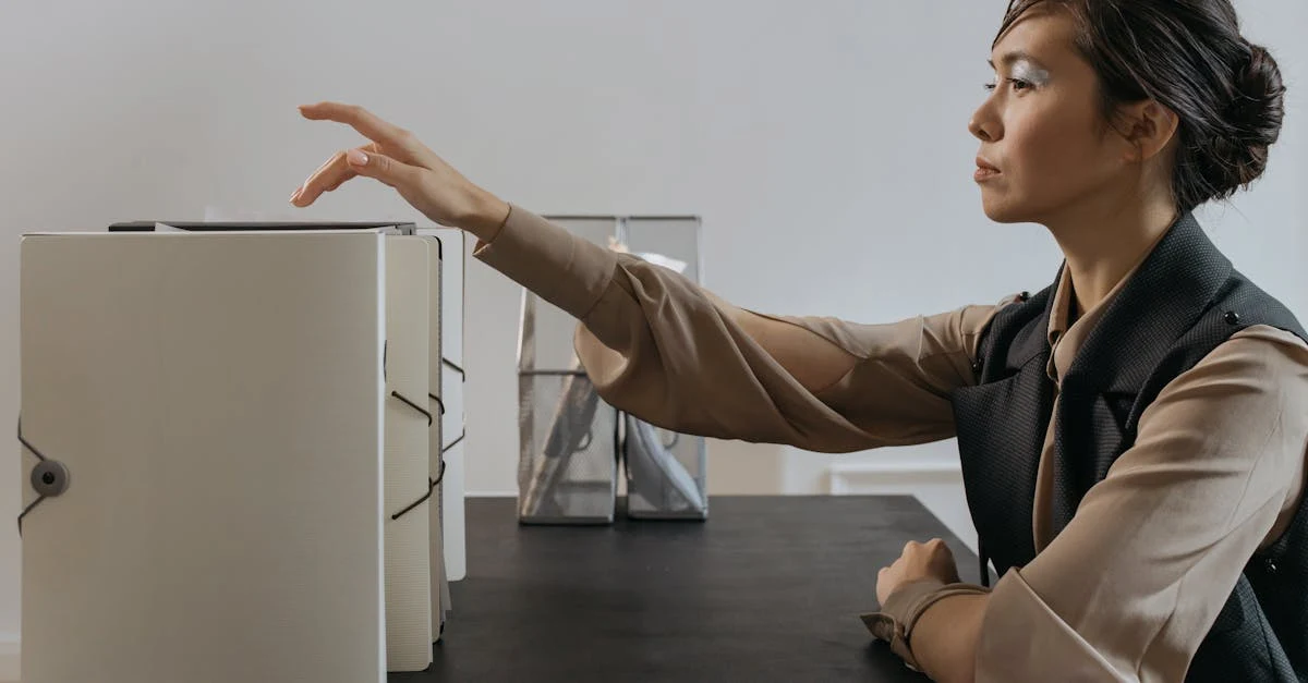 Woman explaining EA finance collaboration strategy at office desk with open notebook and files.