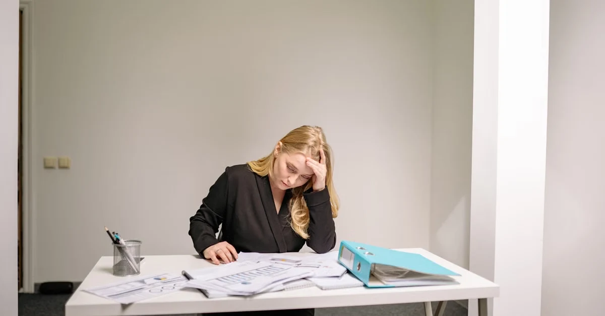 Executive assistant sales leaders reviewing paperwork and documents at desk, showing administrative workload burden.
