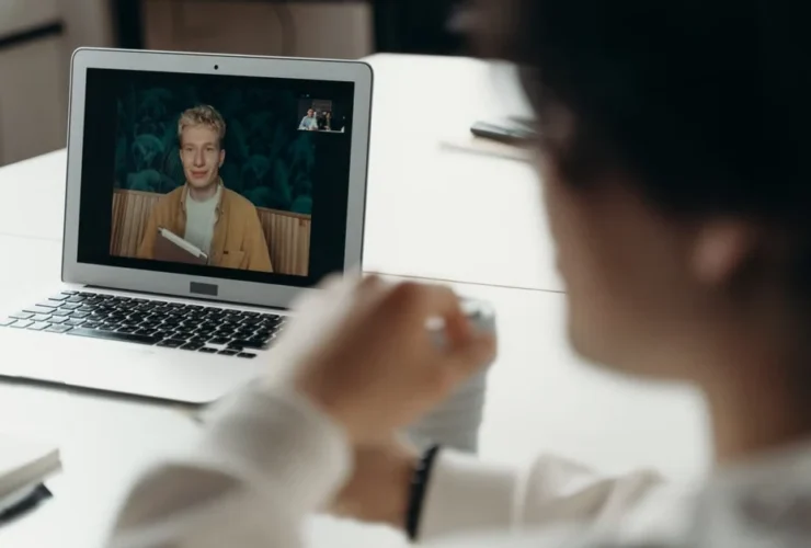 Person on laptop screen during virtual meeting demonstrating time management service model effectiveness.