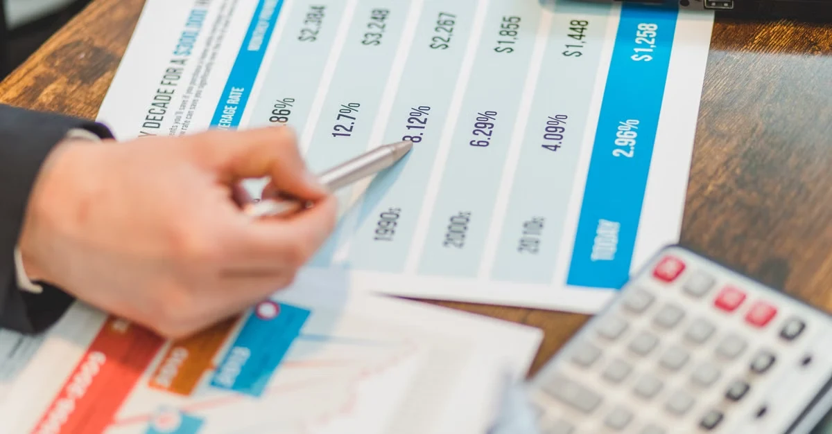 Executive assistant salary data spreadsheet with financial metrics and calculator on desk.